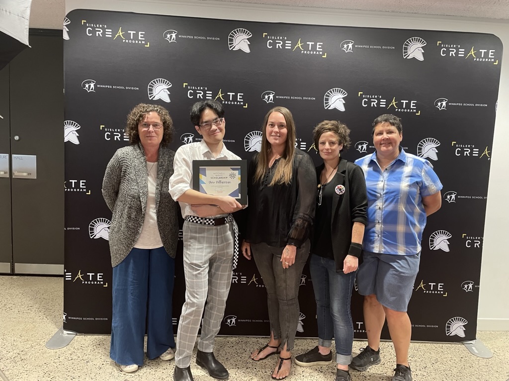 A Sisler CREATE Student receiving a framed certificate standing with 4 people in front of a CREATE Program backdrop